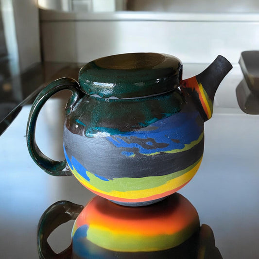 A 2-cup teapot made from black clay, featuring intricate inlays of layered colored clay.